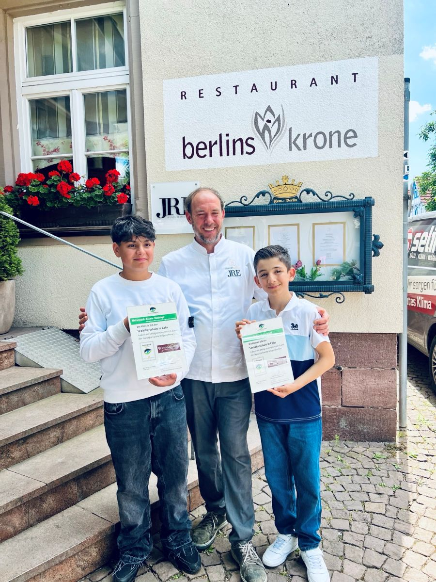 Herr Franz Berlin mit den zwei Klassensprechern und den Urkunden für das Projekt